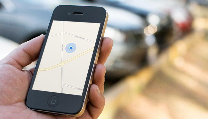 woman-holding-black-iphone-looking-at-blue-dot-apple-maps-web