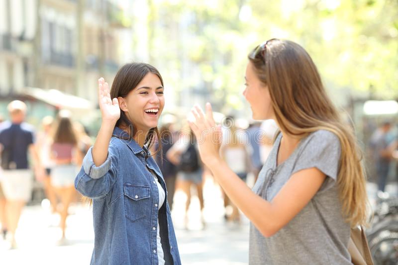 friends-meeting-greeting-street-two-happy-friends-meeting-greeting-street-125188771