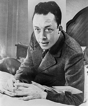 Albert Camus, gagnant de prix Nobel, portrait en buste, pose au bureau, faisant face a gauche, cigarette de tabagisme