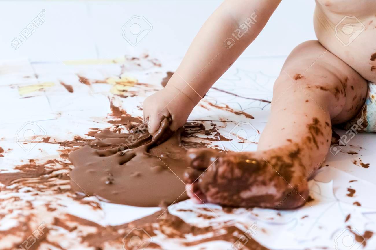 87804168-baby-sitting-painting-with-hands-with-chocolate